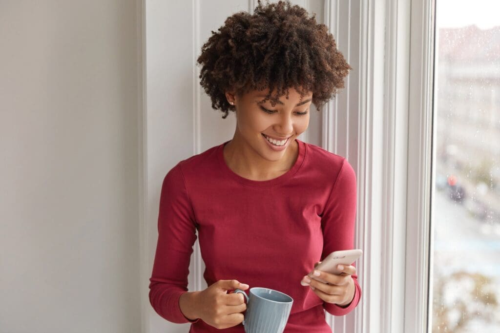 Happy pretty black girl happy to develop her own blog, rejoices having many followers, reads comment