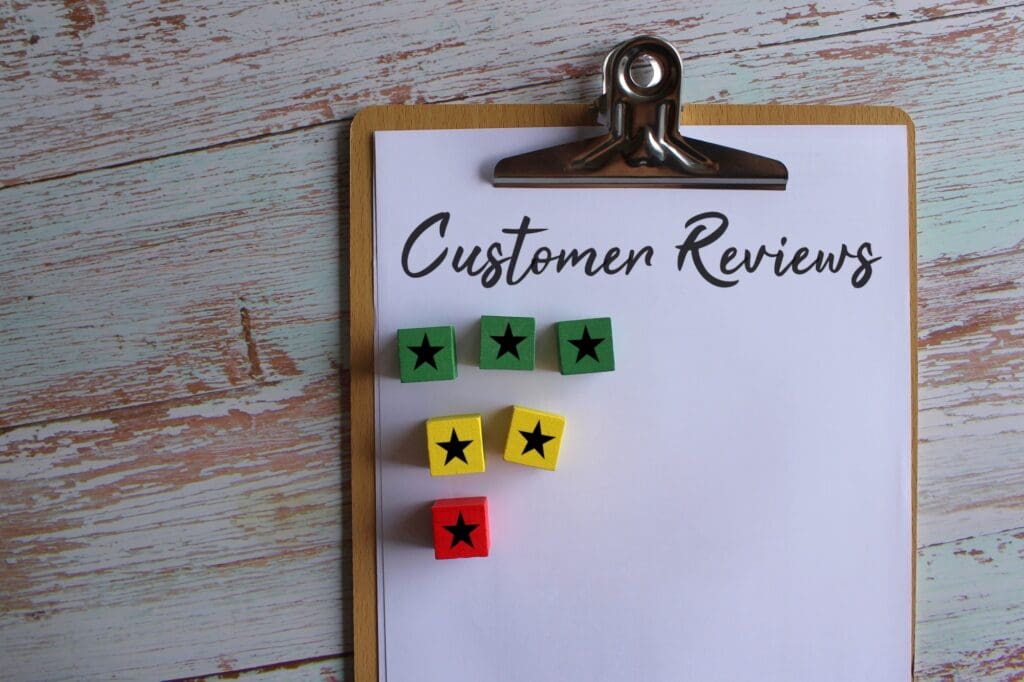 Paper clipboard with text Customer Reviews and wooden cube with star icon